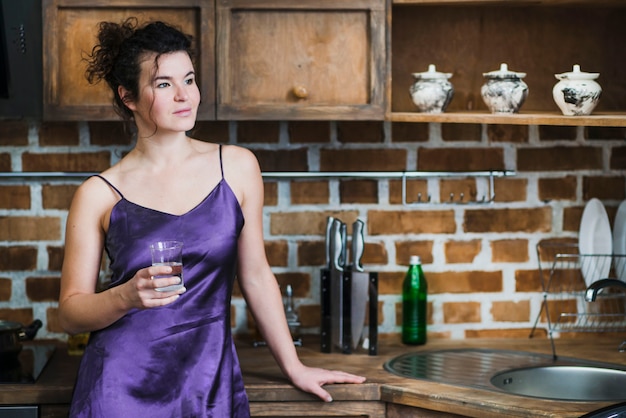 Mujer con agua en cocina con estilo