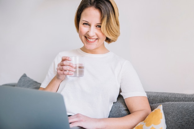 Foto gratuita mujer con agua y portátil