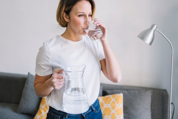 Foto gratuita mujer agua potable en la sala de estar