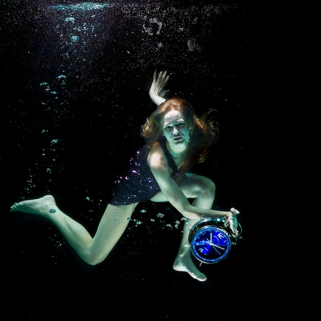 Mujer bajo el agua con un reloj