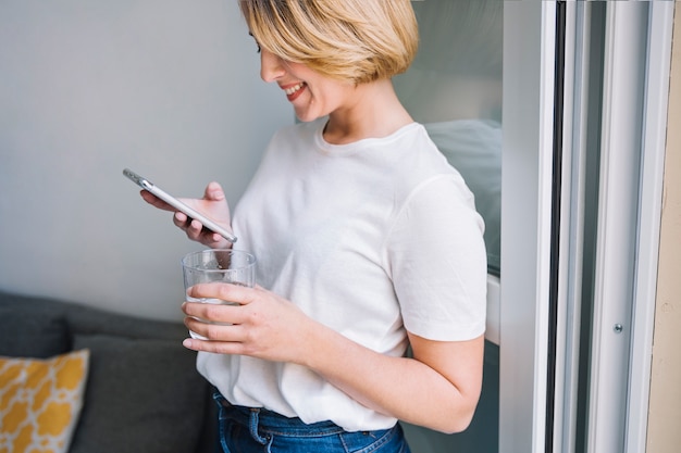 Foto gratuita mujer con agua usando teléfono inteligente