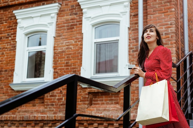 Mujer, aire libre, tenencia, tarjeta de crédito, y, bolsas de compras