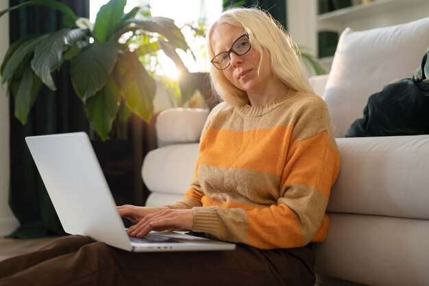 Foto gratuita mujer albina en casa haciendo tareas