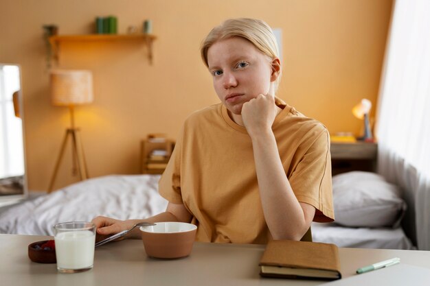 Mujer albina de tiro medio desayunando