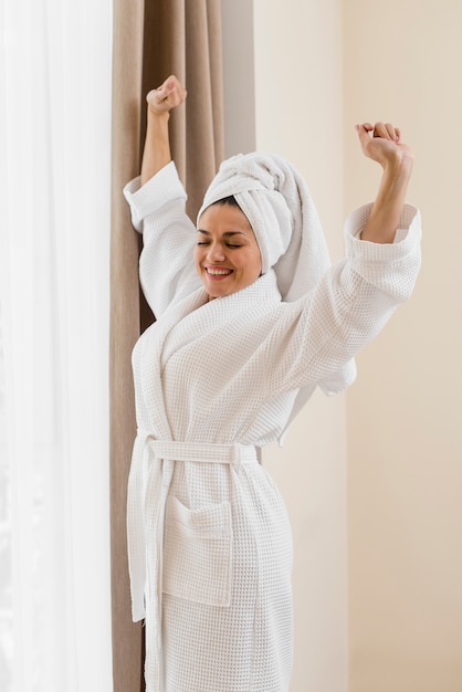 Mujer con albornoz en habitación de hotel