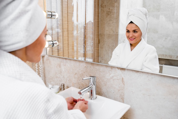 Mujer con albornoz en habitación de hotel