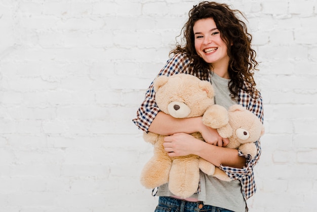 Foto gratuita mujer alegre abrazando peluches