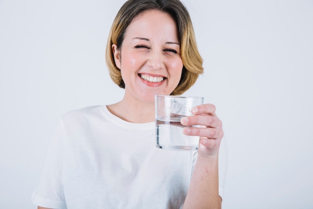 Mujer alegre con agua sobre fondo blanco