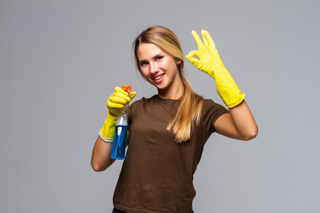 Mujer alegre ama de llaves mostrando signo ok como gran concepto de servicios de limpieza en blanco