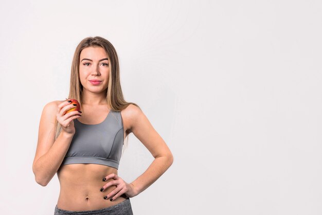 Mujer alegre atractiva con manzana