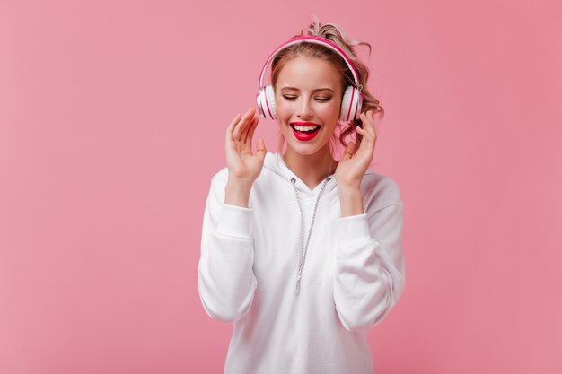 Mujer alegre en auriculares grandes le encanta escuchar música