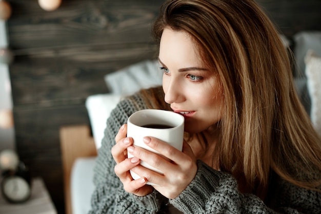 Mujer alegre bebiendo café por la mañana