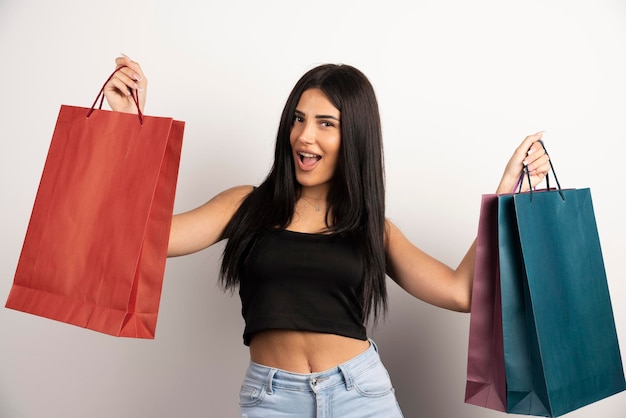 Mujer alegre con bolsas de la compra sobre fondo beige. Foto de alta calidad