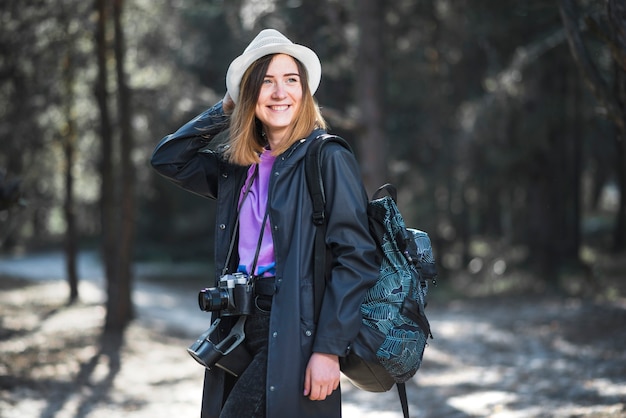 Foto gratuita mujer alegre con cámara y mochila