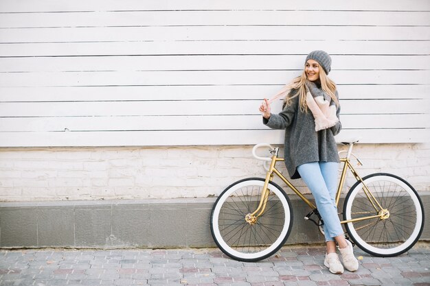 Mujer alegre cerca de bicicleta