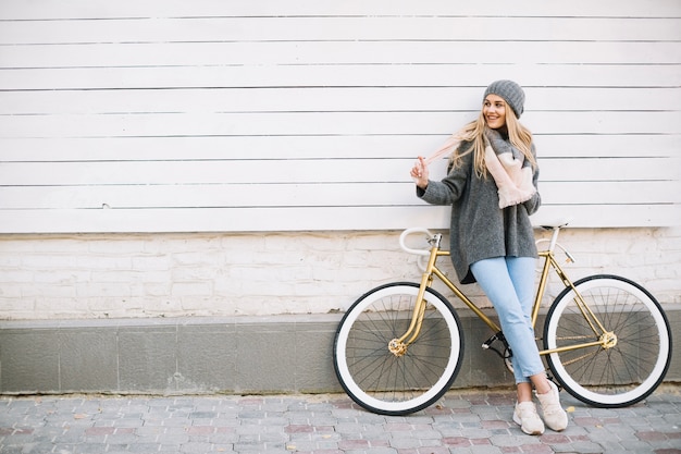 Mujer alegre cerca de bicicleta