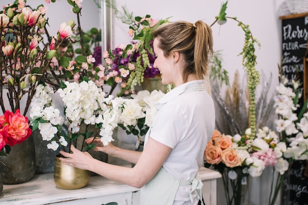 Mujer alegre emocionada con flores componiendo