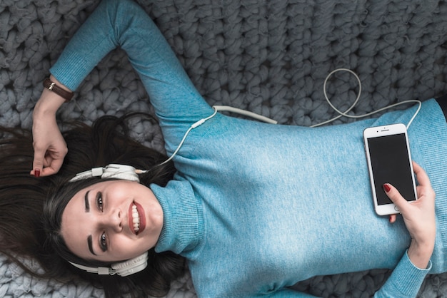 Mujer alegre escuchando música en el sofá