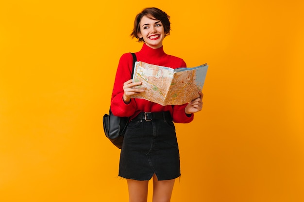 Mujer alegre en falda negra preparándose para viajar