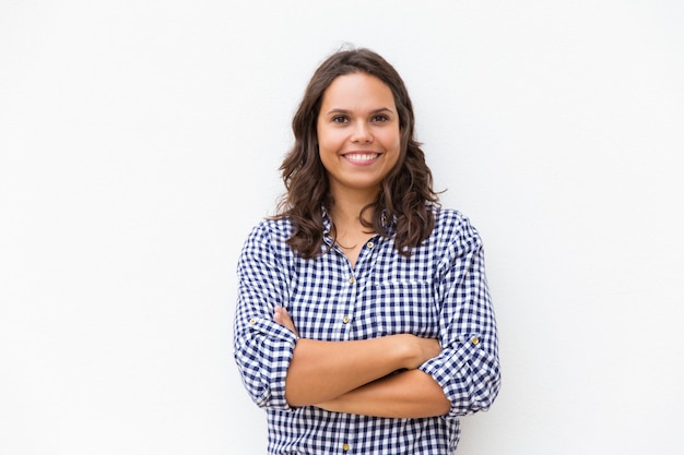 Mujer alegre feliz con los brazos cruzados mirando