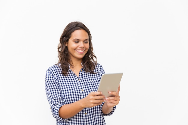 Mujer alegre feliz que usa la tableta