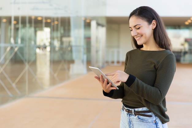 Mujer alegre feliz con tableta usando internet