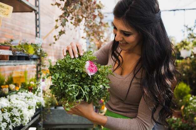 Mujer alegre con flor en maceta