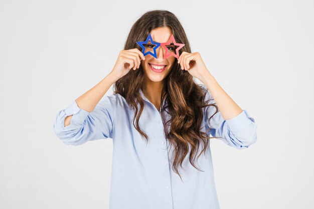 Mujer alegre en gafas en forma de estrella