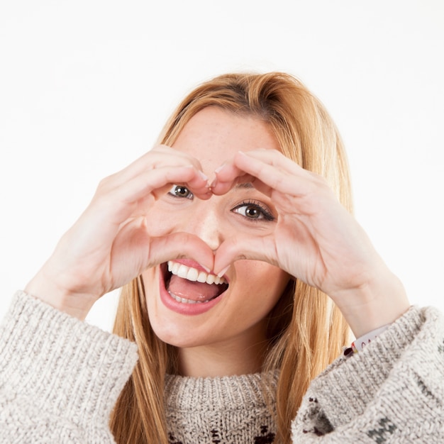 Mujer alegre haciendo gesto de corazón