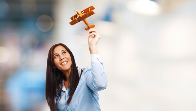 Mujer alegre jugando con un avión de juguete