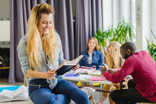 Foto gratuita mujer alegre con el libro en el aula