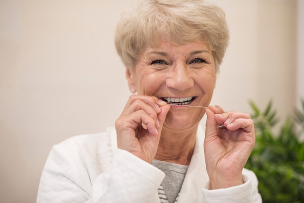 Mujer alegre limpiando sus dientes