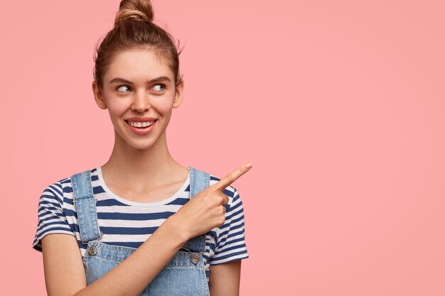 Mujer alegre con moño, vestida con ropa casual