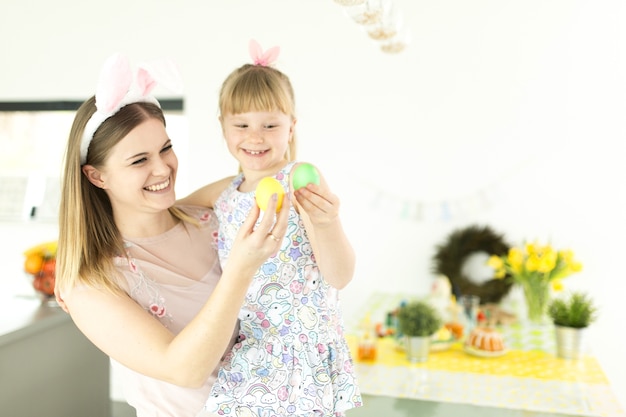 Mujer alegre y niña con huevos