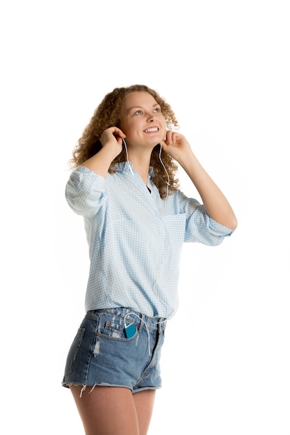 Mujer alegre en pantalones cortos escuchando música