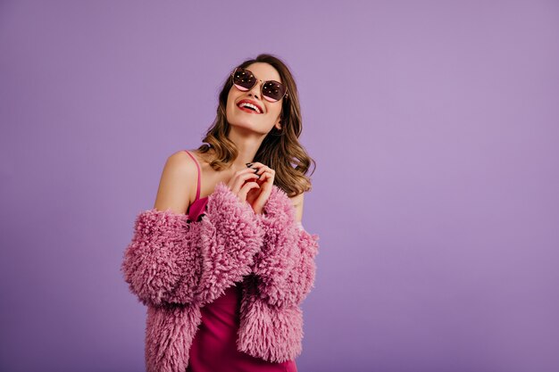 Mujer alegre posando en chaqueta ecológica púrpura