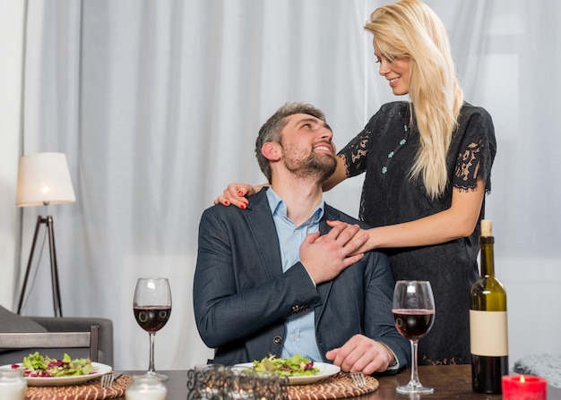 Foto gratuita mujer alegre que abraza al hombre en la tabla con las placas y los vidrios