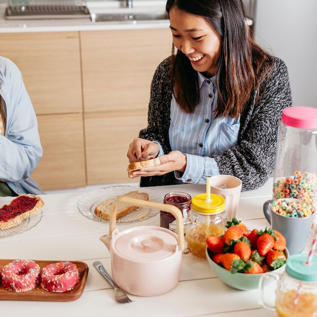 Foto gratuita mujer alegre que hace el desayuno con un amigo