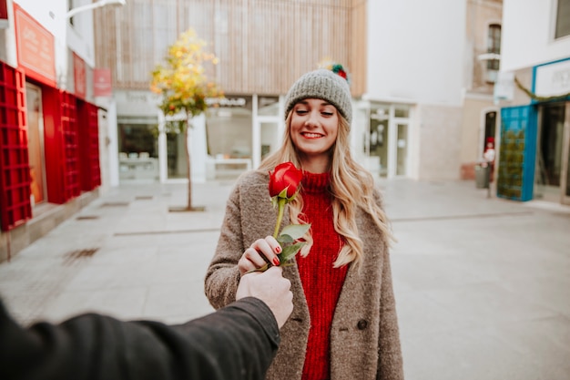 Mujer alegre que recibe rosa