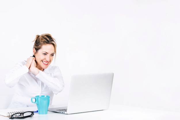 Mujer alegre que usa la computadora portátil