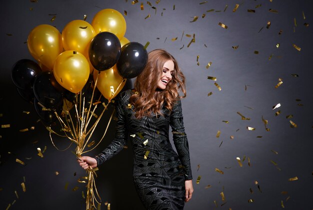 Mujer alegre con ramo de globos