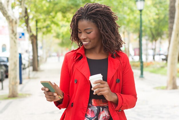 Mujer alegre con smartphone en el parque