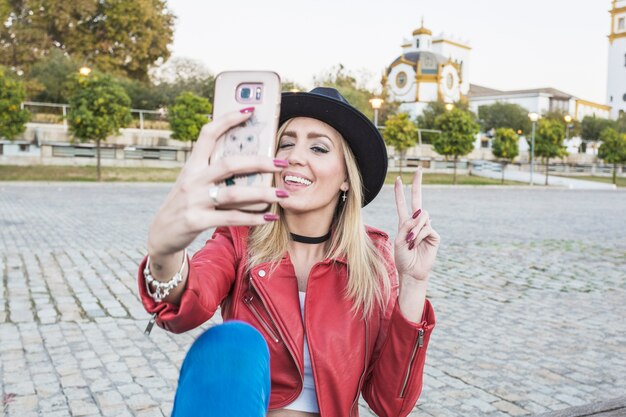 Mujer alegre tomando selfie en la calle