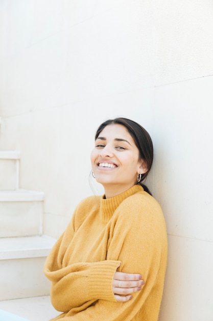 Foto gratuita mujer alegre vistiendo sudadera sentado en la escalera