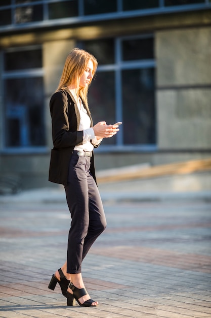 Foto gratuita mujer alejándose mientras usa su teléfono