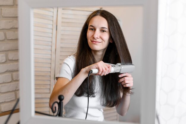 Mujer alisándose el cabello