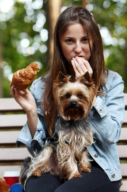 Mujer almorzar paseando con su perro