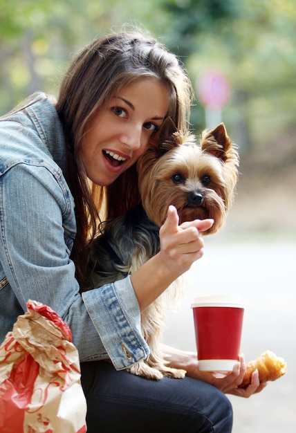 Mujer almorzar paseando con su perro