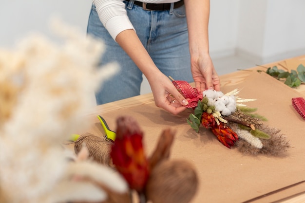 Mujer alta vista arreglando un hermoso ramo de flores