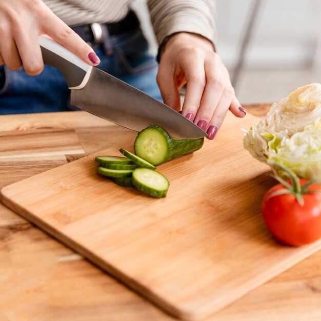 Mujer alta vista cortando rodajas de verduras